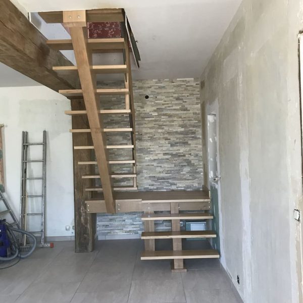 Escalier en chêne à deux quarts tournants, avec un mur en briques, et un palier de repos élégant.
