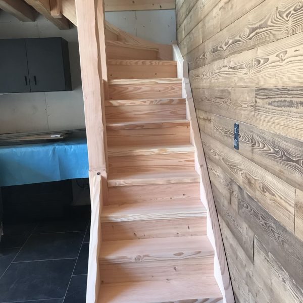 Escalier en bois de Douglas menant à une cuisine dans une maison chaleureuse et accueillante.