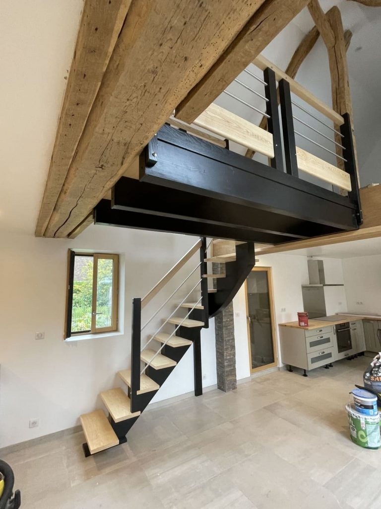 Escalier avec passerelle, intégrant harmonieusement la cuisine et le salon dans un espace de vie convivial.