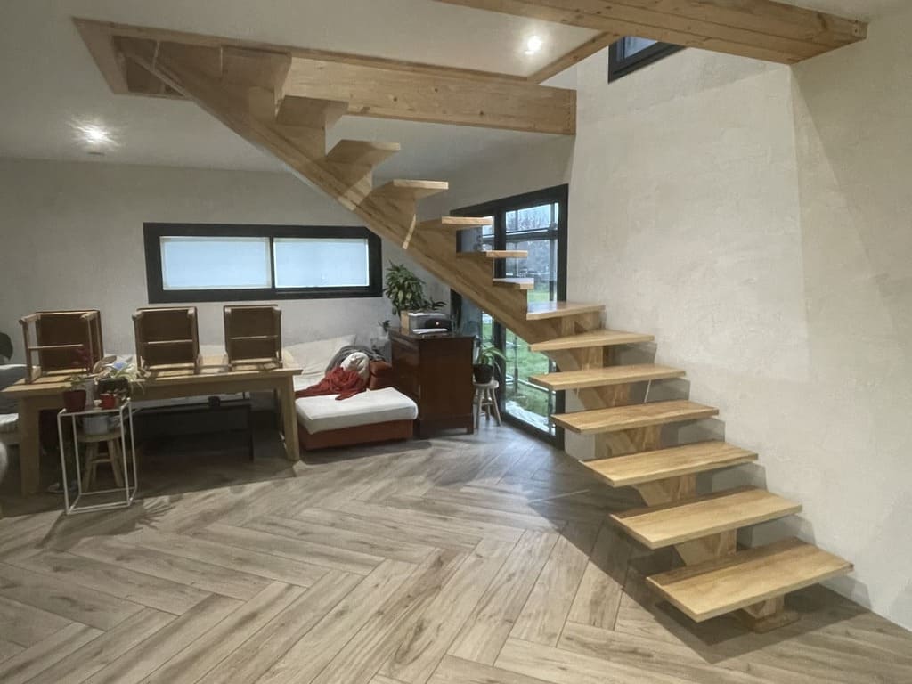 Petite pièce avec un escalier en bois limon central en frêne et un bureau, alliant élégance et praticité dans un espace réduit.
