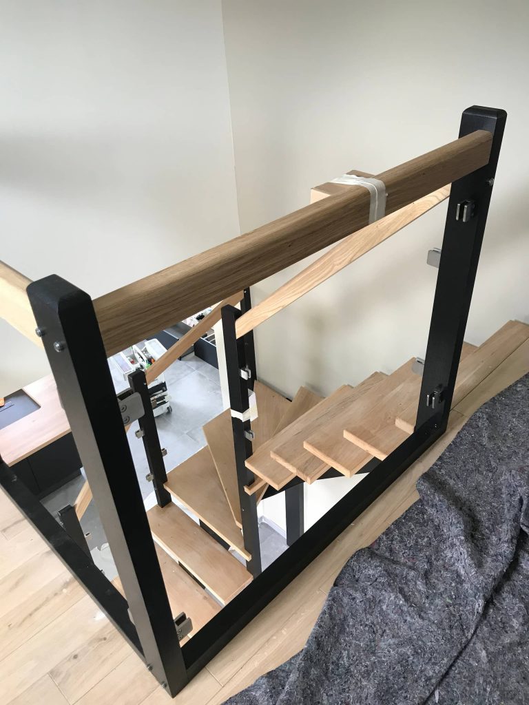 Vue du haut escalier à limon central bois peint avec marches en frêne et garde-corps verre réalisé à Évreux