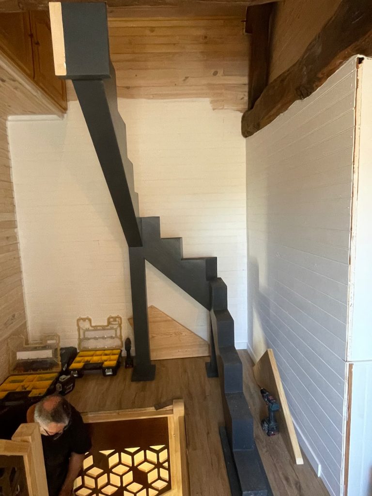 Escalier sur mesure à limon central avec structure métallique et marches en bois massif installé à Louviers